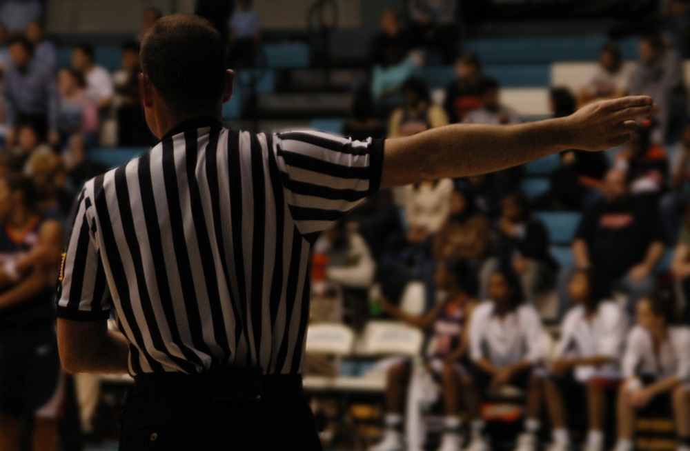 A referee makes a call on the court at a basketball game