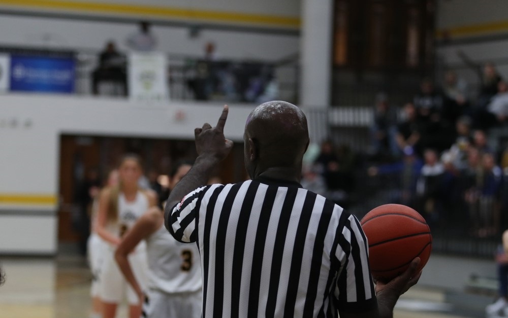 Basketball referee holding the ball during a game