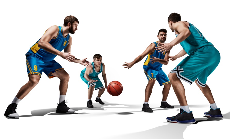 Four basketball players facing off for the ball