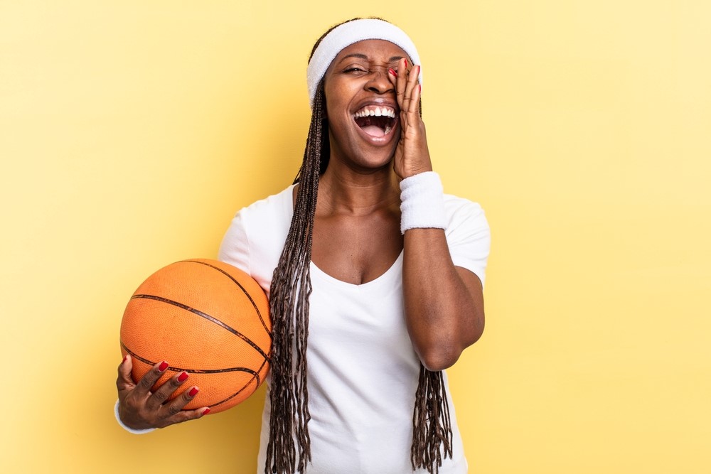 Happy basketball player holding the ball