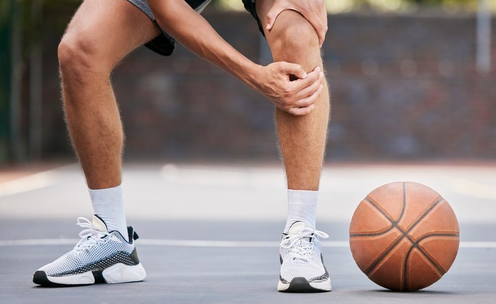 Man with a knee injury on a basketball court