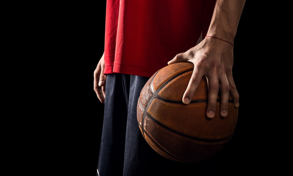 Young man palms a basketball in his left hand