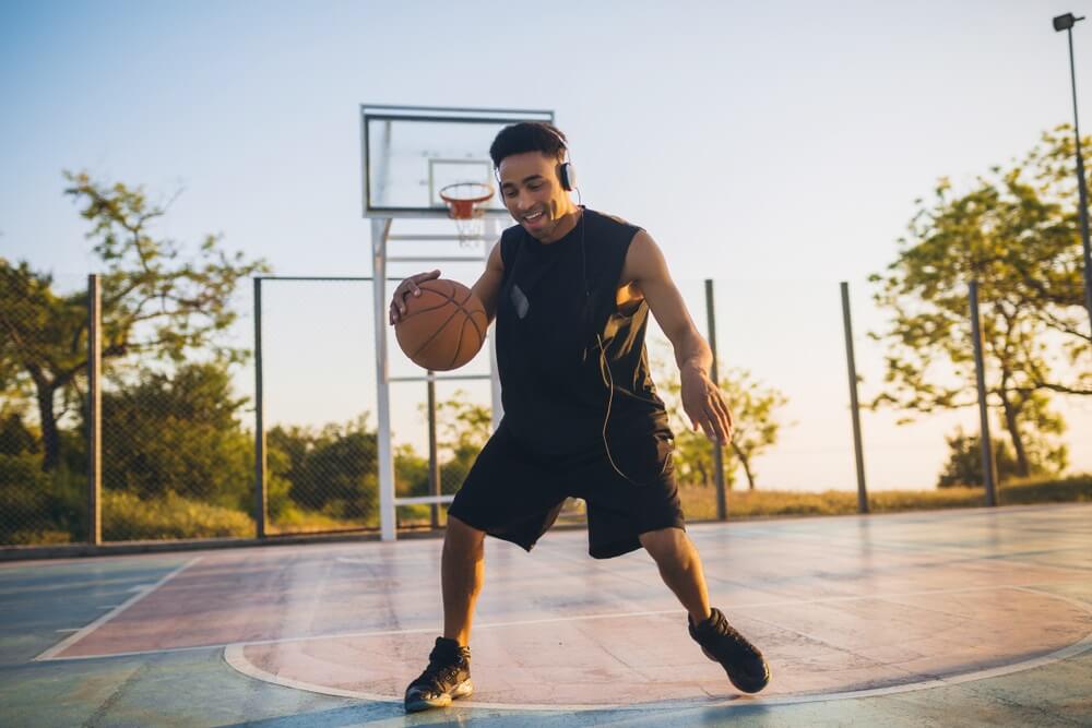 Young man smiling playing basketball